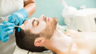 profile view young man getting moisturizing facial treatment health spa